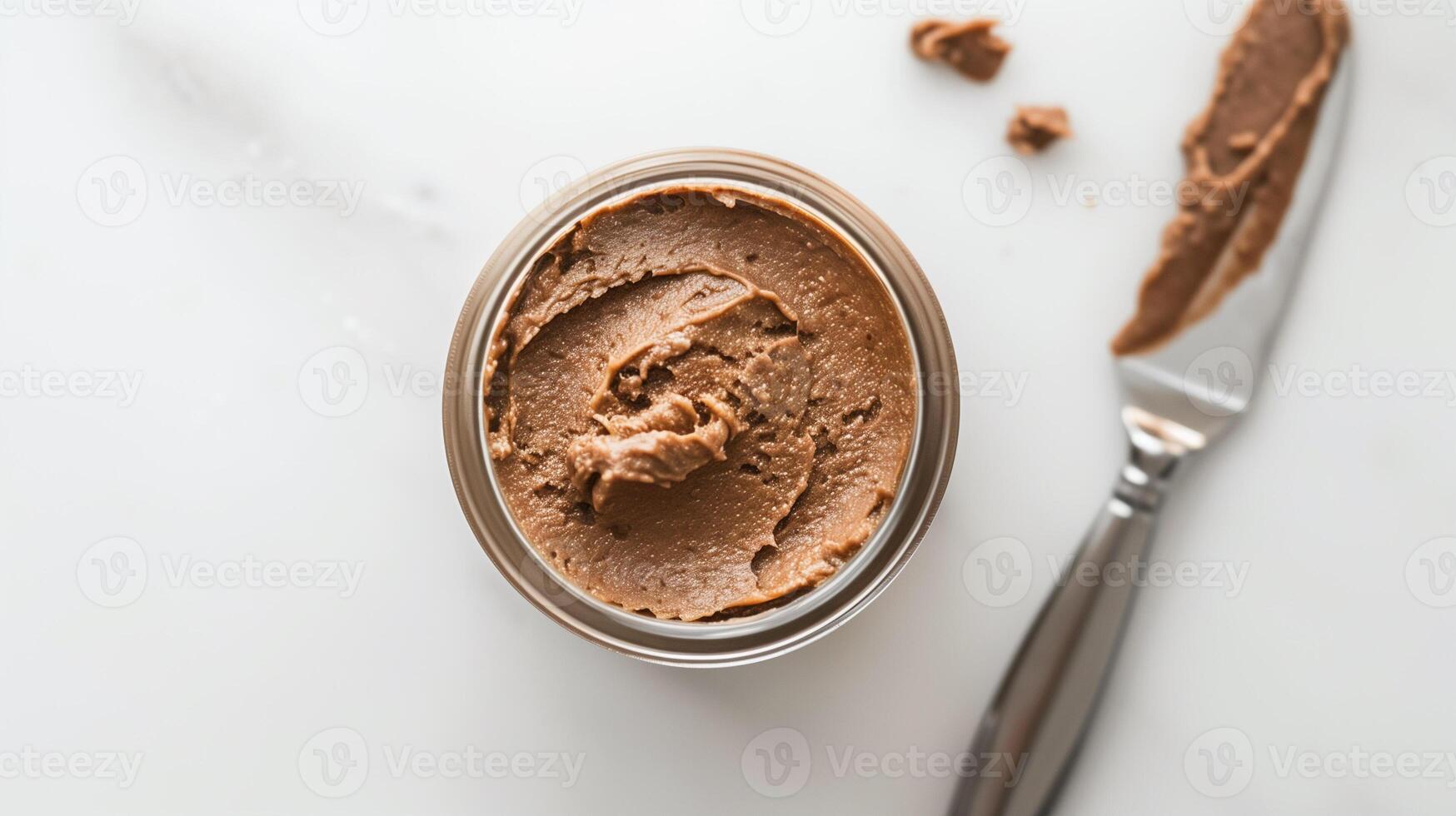 Glass jar of nut-free spread on a white background with a spreading knife, food photography photo