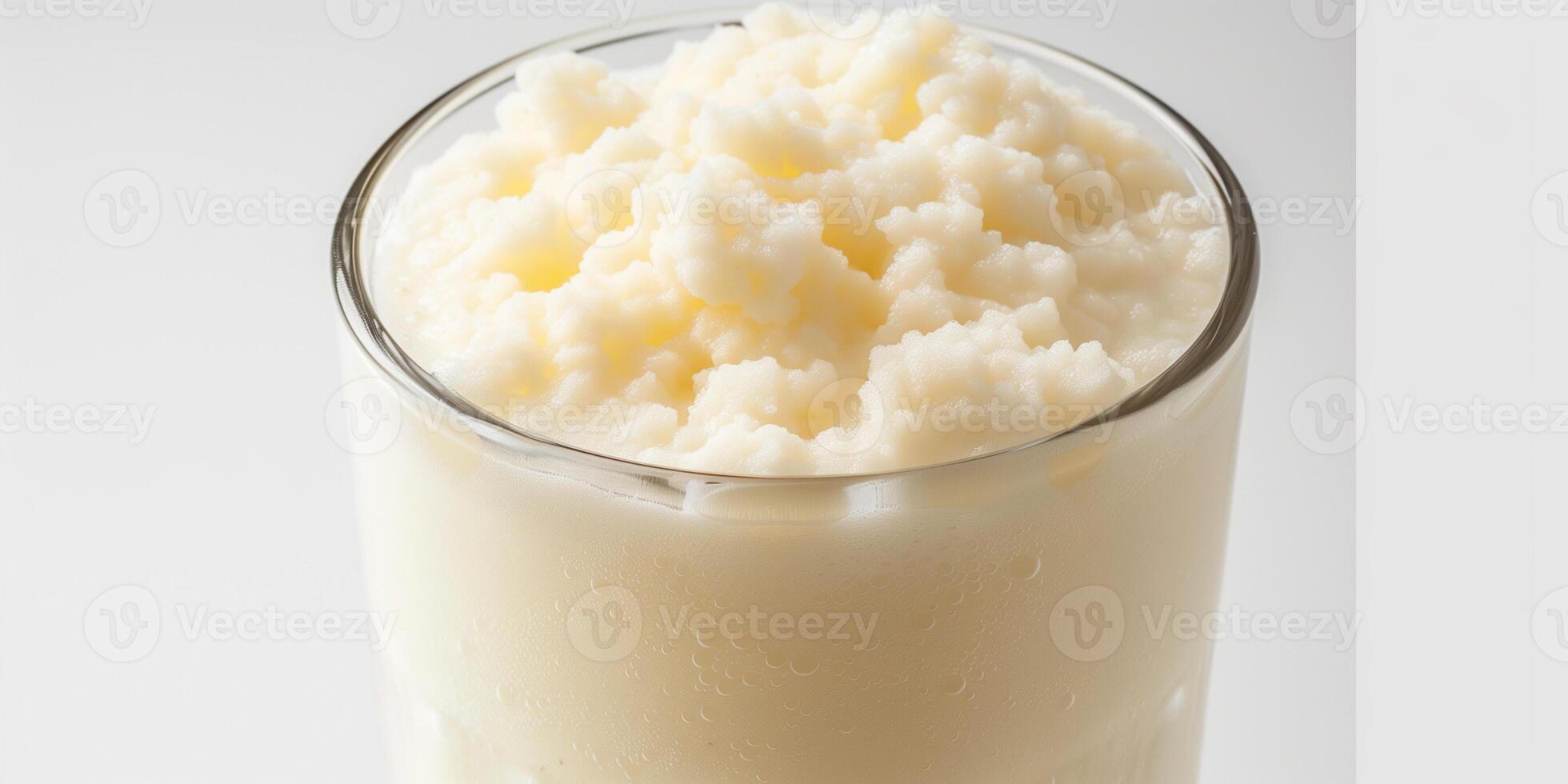 Glass filled with kefir, showing its slightly frothy surface, placed on a plain white background, culinary photography photo