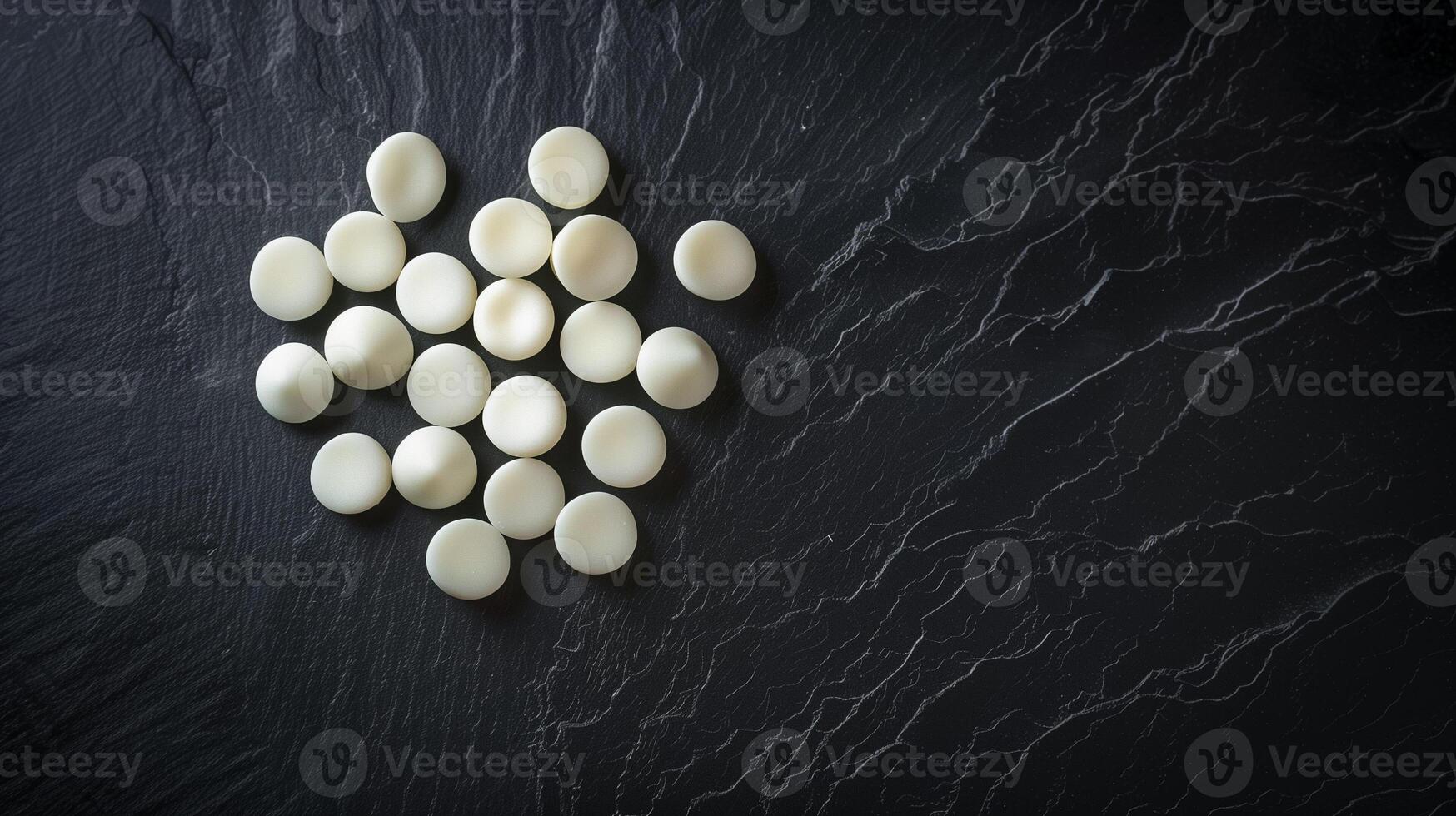 Unwrapped white mints arranged in a circular pattern on a dark surface, gastronomy photography photo