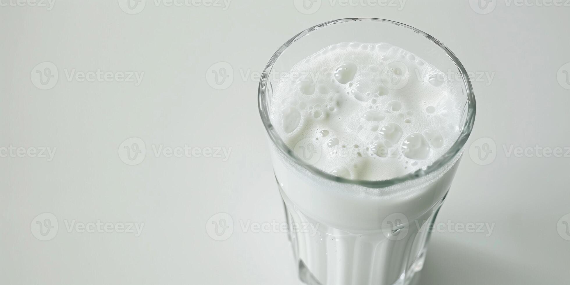 Glass filled with kefir, showing its slightly frothy surface, placed on a plain white background, food setting photo