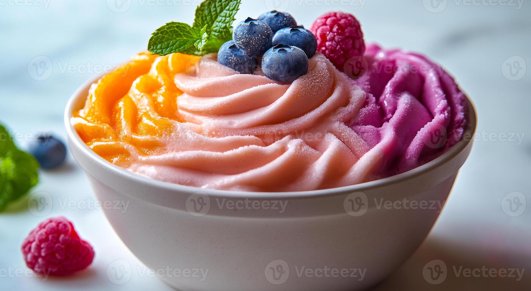 A bowl of ice cream with blueberries and raspberries. The ice cream is pink, orange, and purple photo