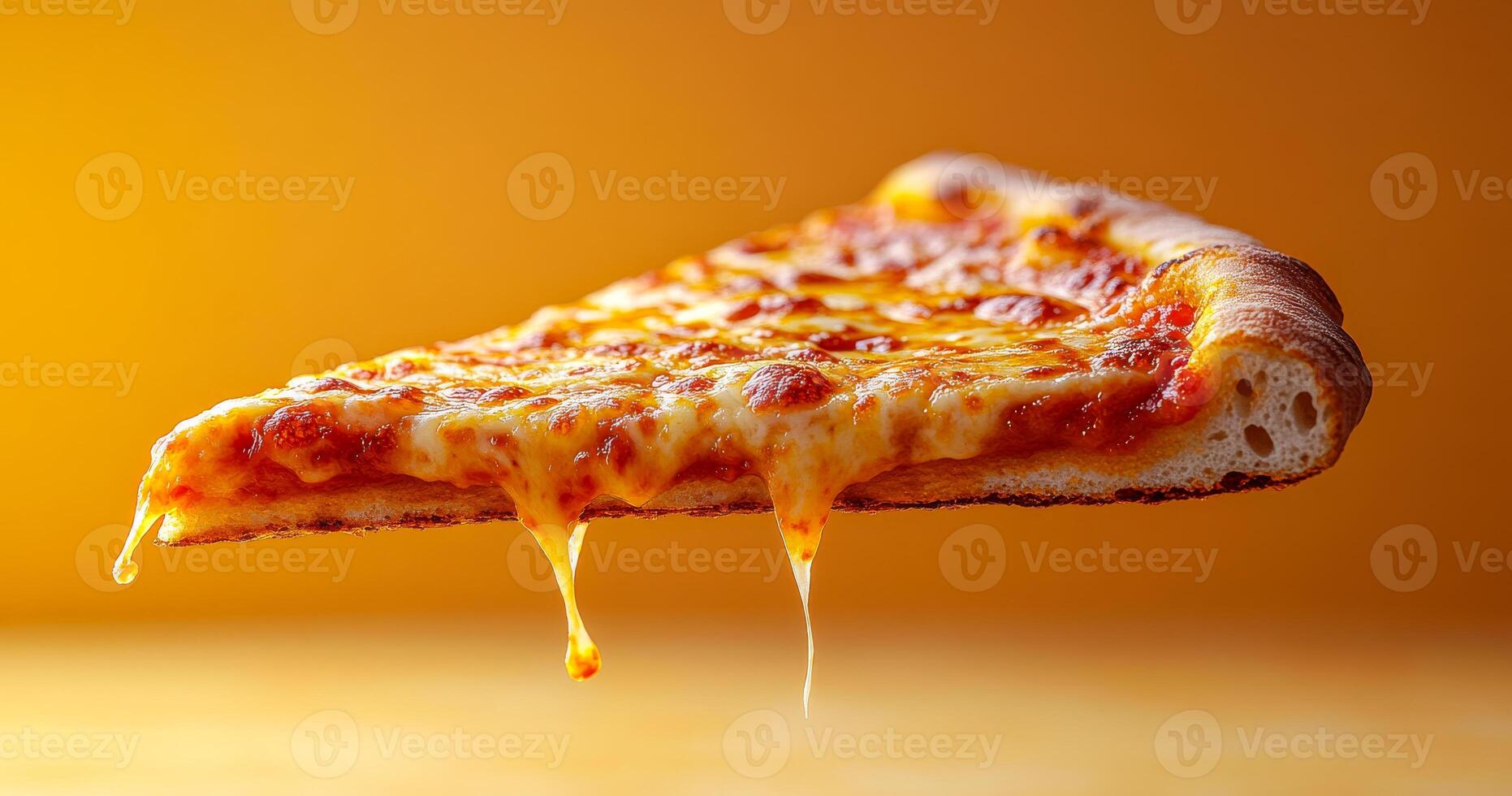 A slice of pizza with melted cheese on top. The slice is in the air, and the cheese is dripping down photo