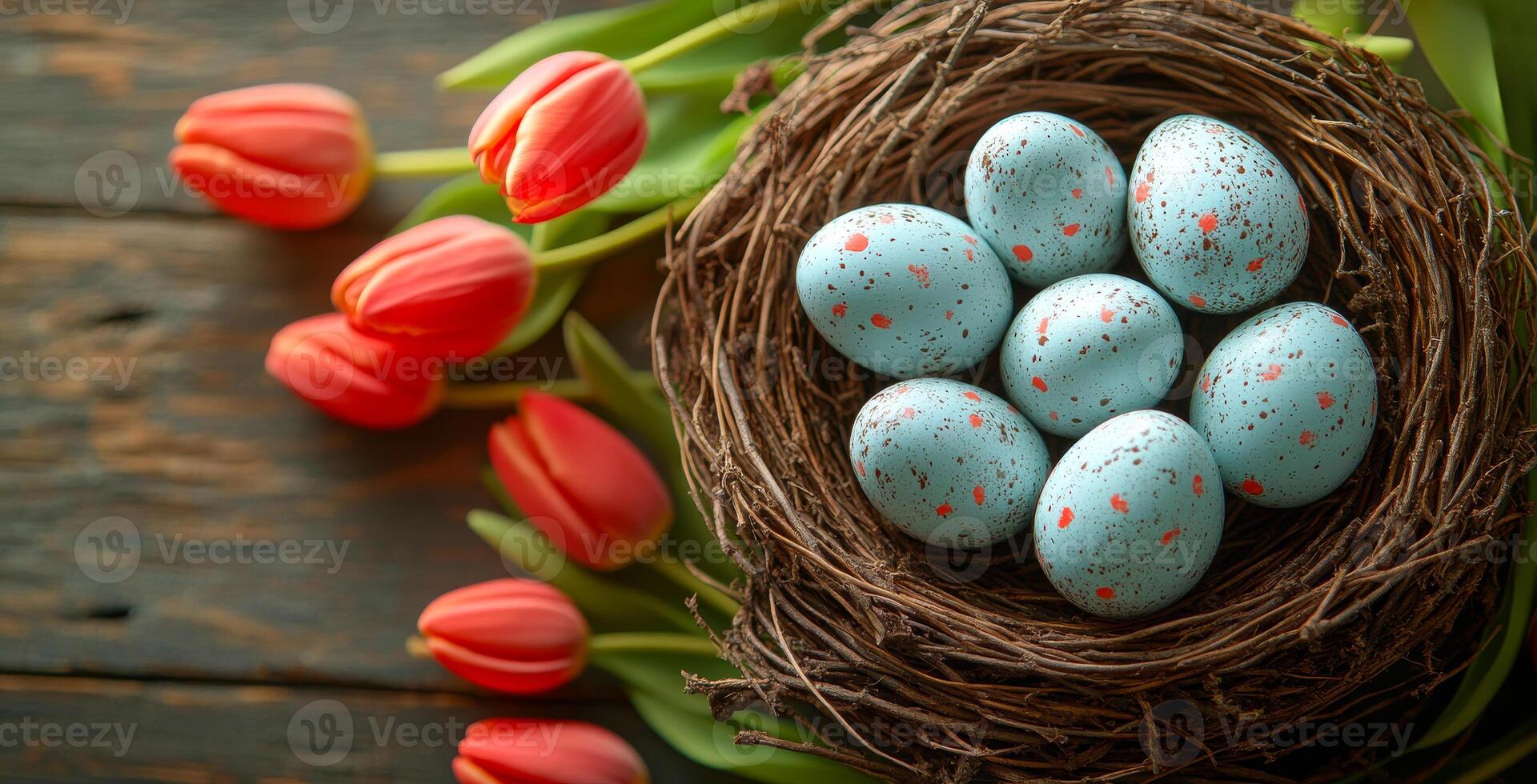 A nest of eggs sits on a wooden table next to a vase of red flowers. The eggs are blue and white, and the flowers are red. Concept of warmth and comfort, as the eggs photo