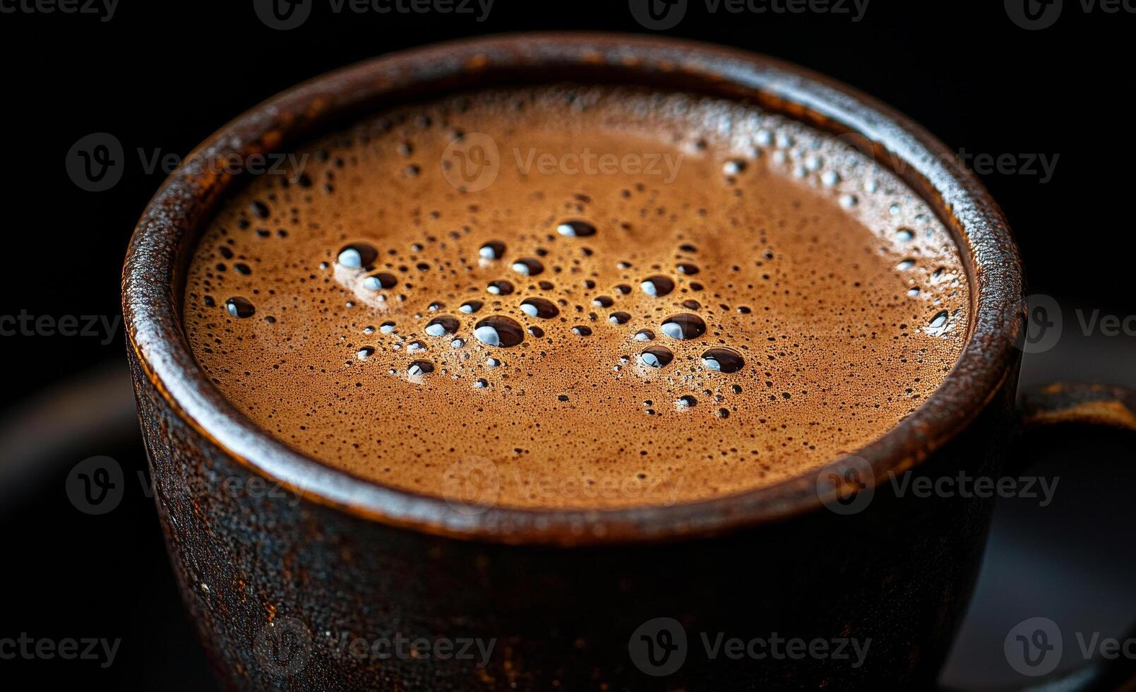 A cup of coffee with foam on top. The foam is bubbly and the coffee is brown photo