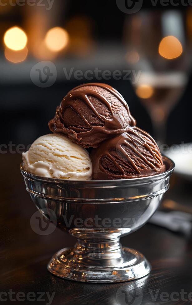 Enjoying delicious ice cream in an elegant setting. Three scoops of ice cream in a silver bowl are presented in a warm, dimly lit environment, perfect for dessert lovers. photo