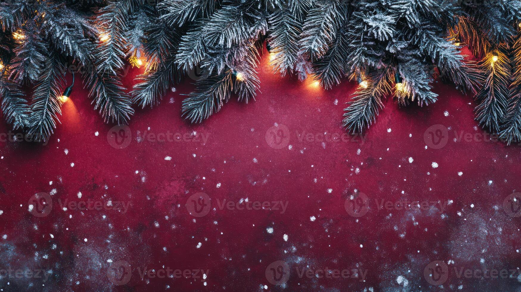 Frosted Pine Branches Adorned with Warm Lights Against a Rich Red Background and Light Snowflakes for a Cozy Winter Holiday Atmosphere photo