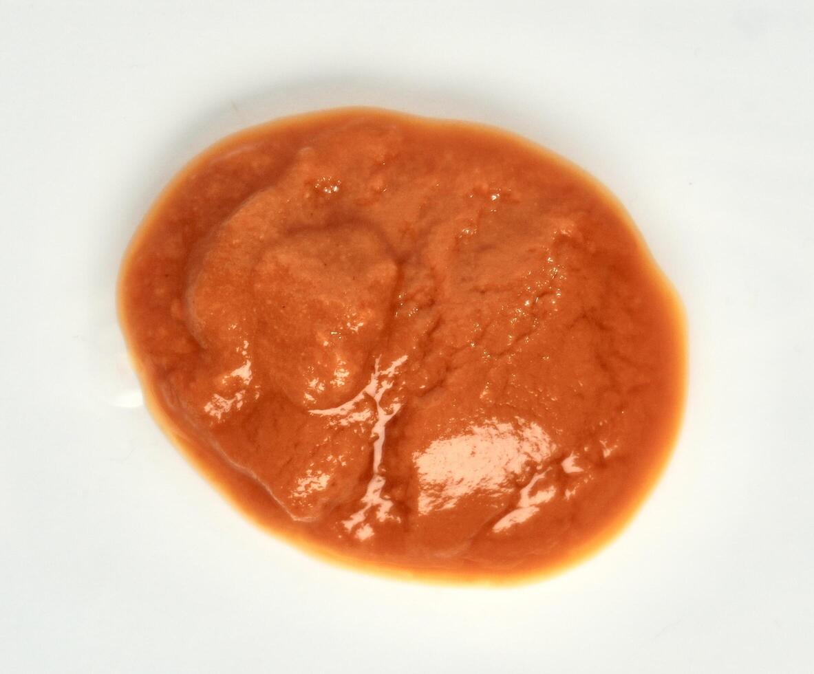 Hot chili sauce or saus sambal red food condiment isolated on white background from above angle view. photo