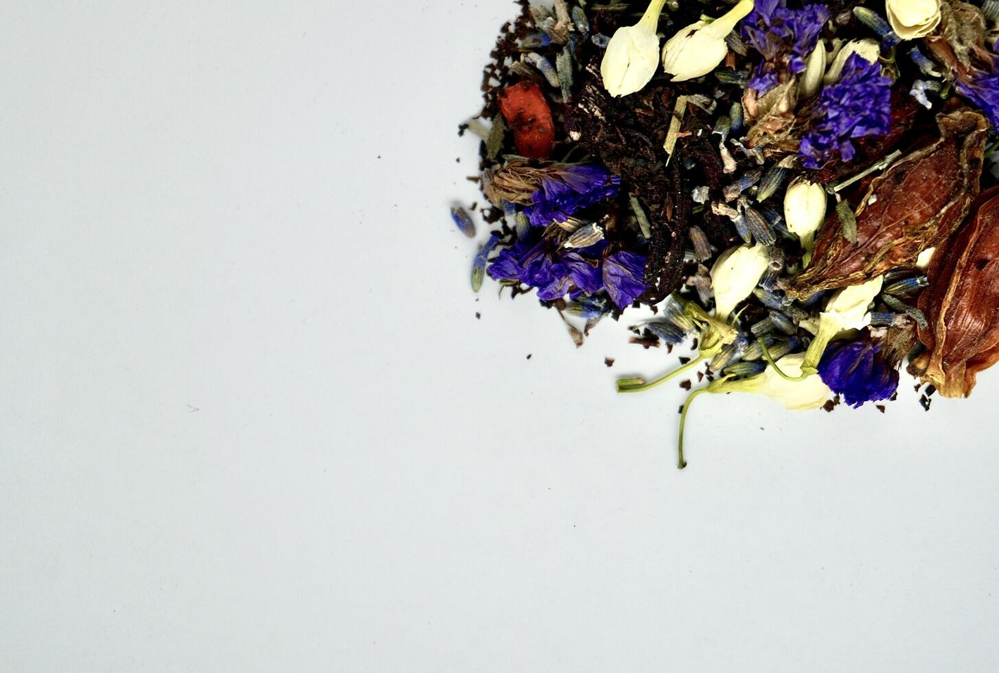 Group of mixed organic earl grey tea, jasmine buds, lavender, gardenia, goji berry, and forget me not flowers isolated on horizontal copy spaced white background. photo