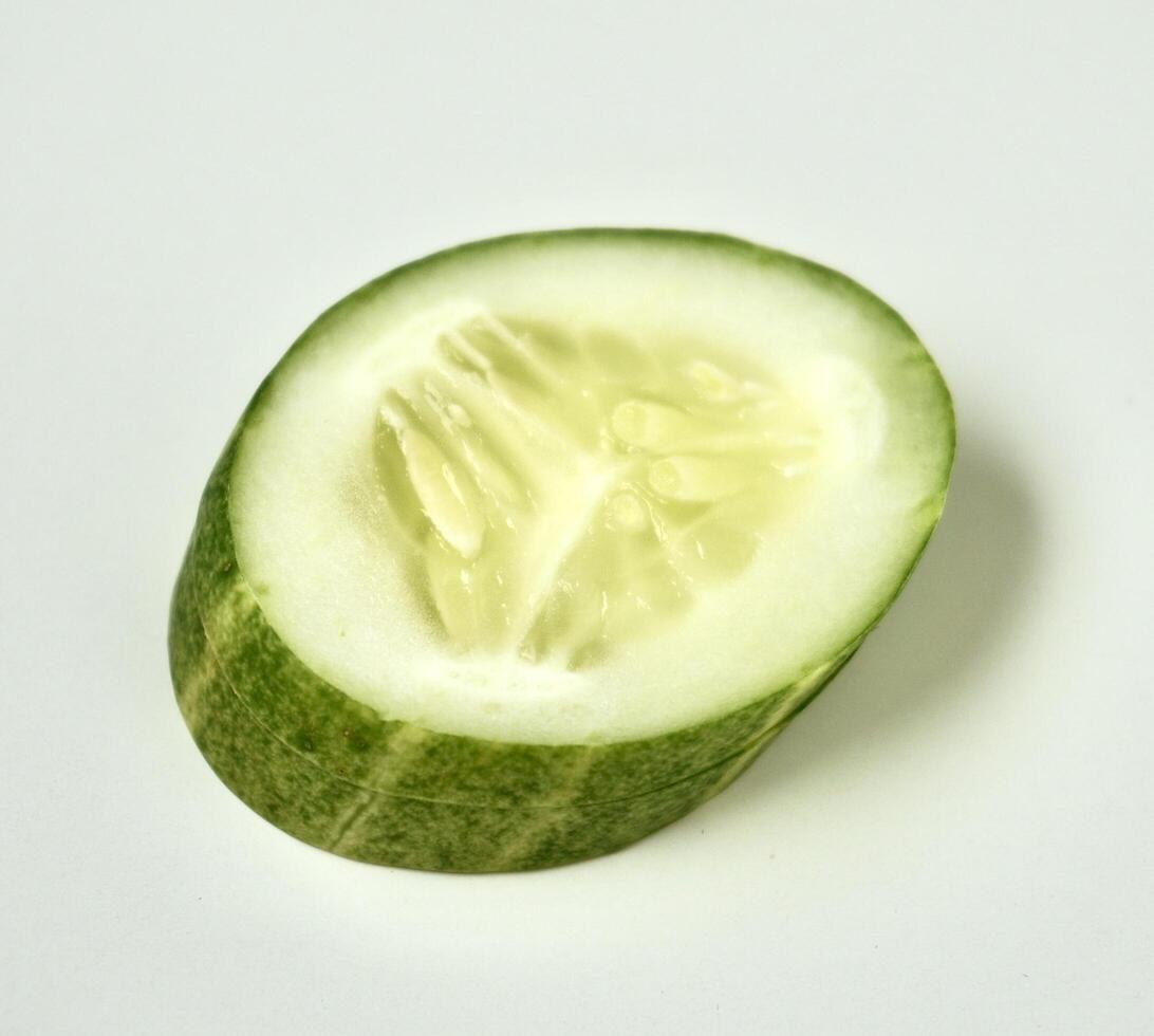One piece of fresh and healthy cucumber vegetable slice isolated on white square background. photo
