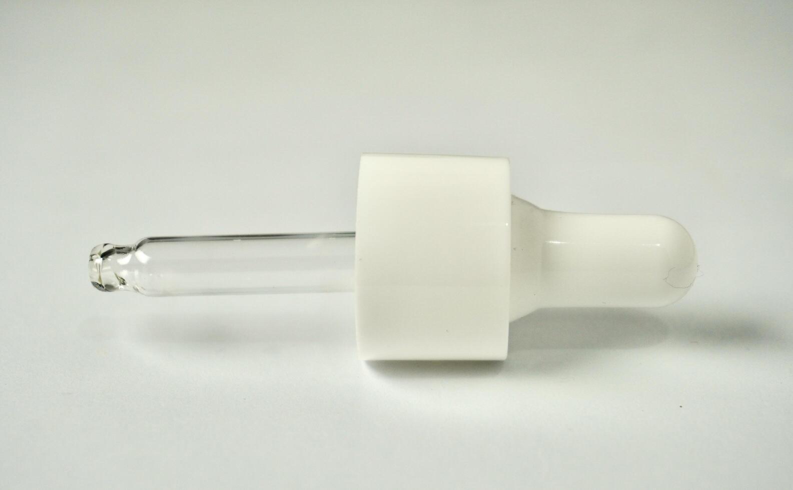 Skin care or health care bottle white pipette pump lid cap object isolated on horizontal background from side angle view. photo