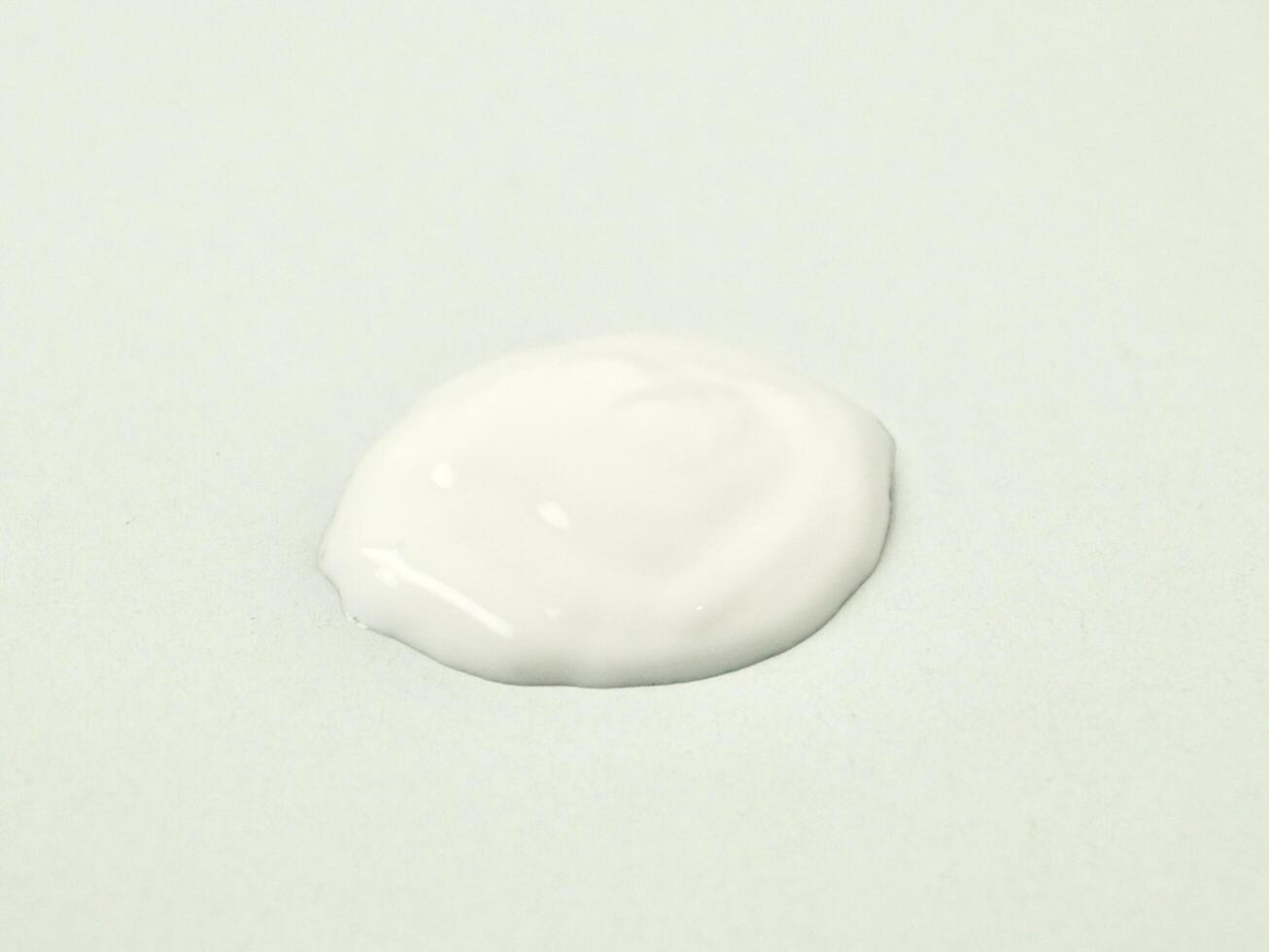 White lotion cream drop texture isolated on horizontal white background. photo