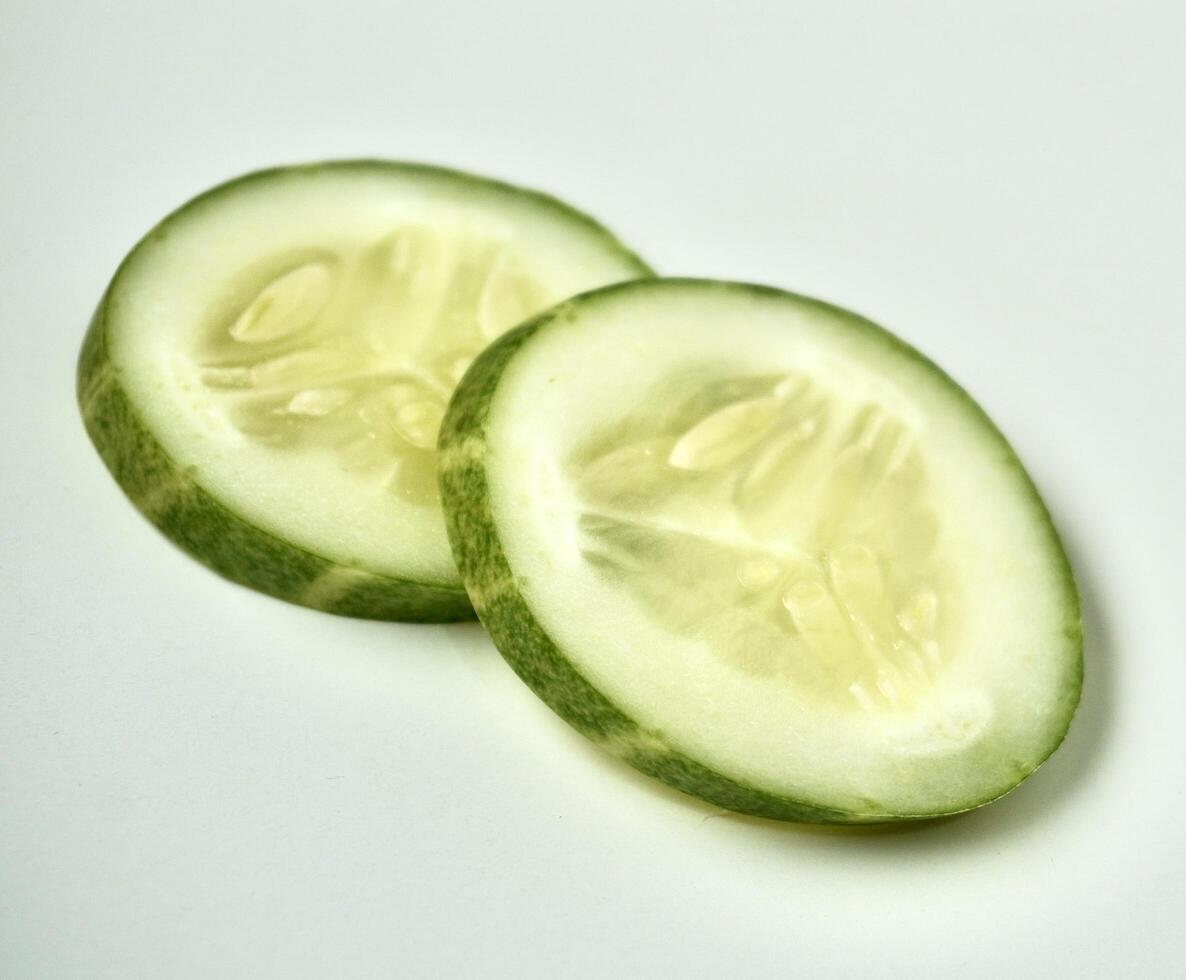 Fresh and healthy two cucumber vegetable slices isolated on horizontal white background. photo