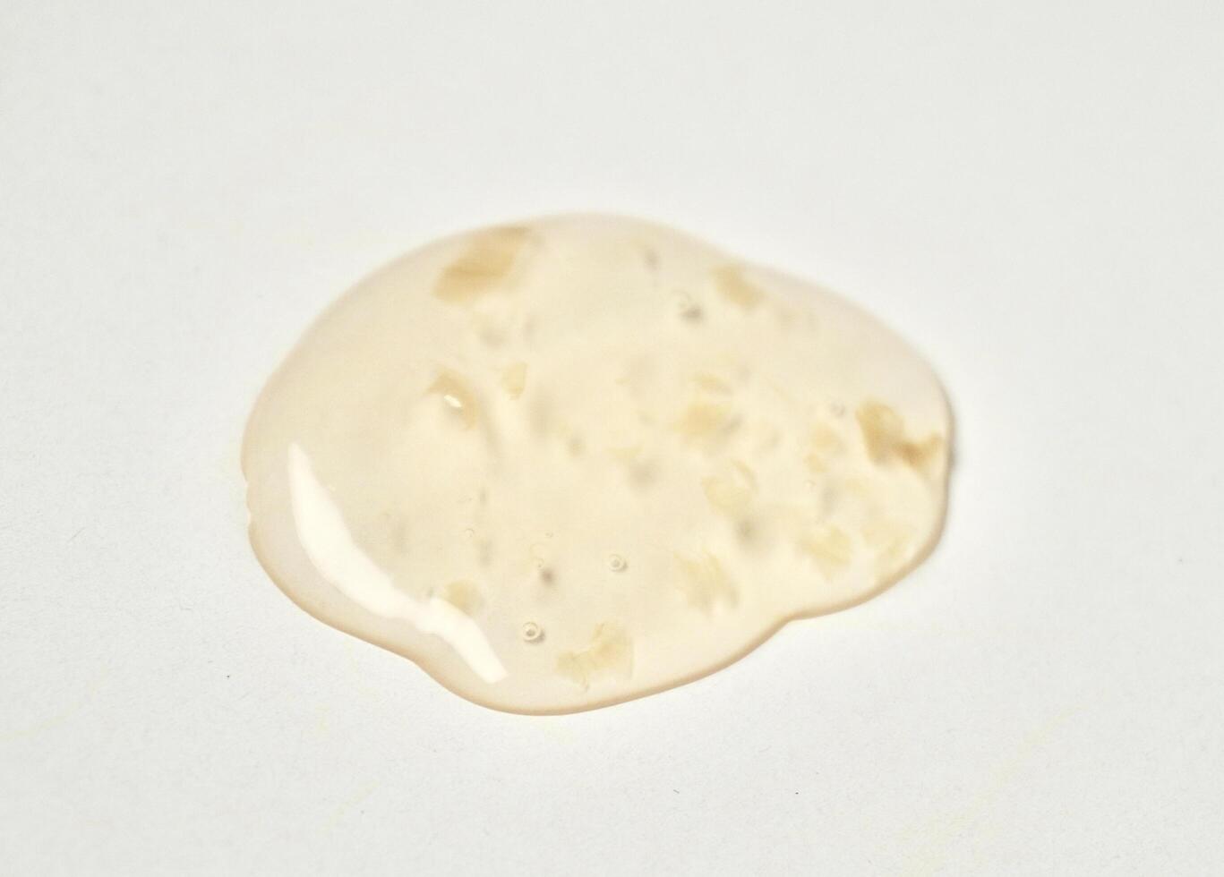 Yellow orange transparent liquid soap body care drop texture isolated on horizontal white background. photo