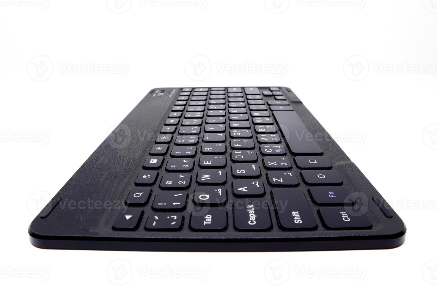 A black wireless keyboard on a white surface photo