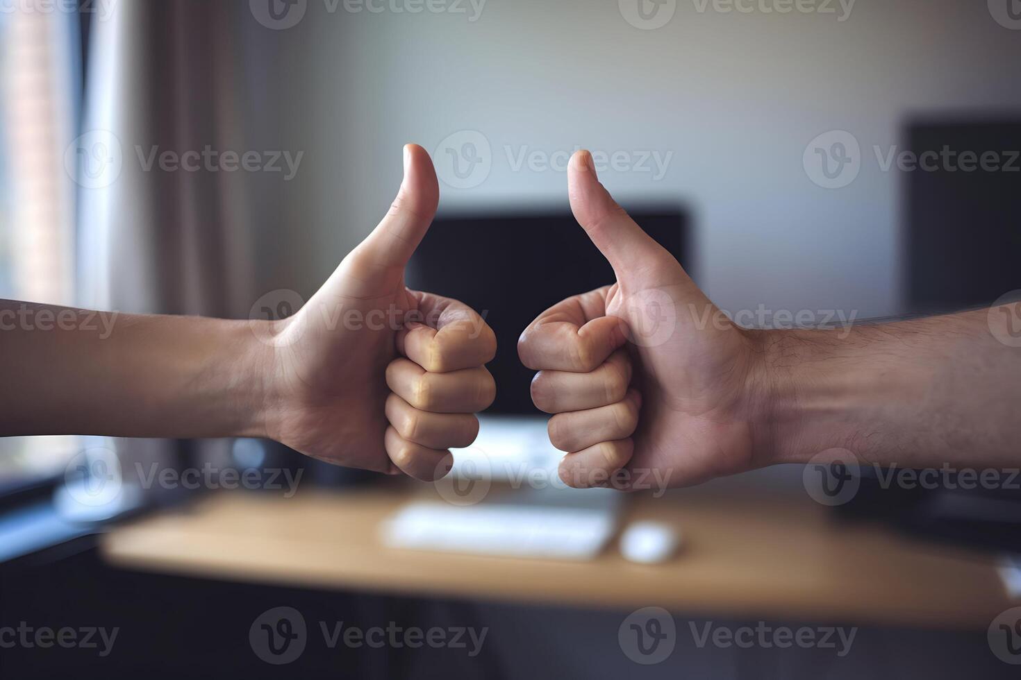 Two hands giving a thumbs up gesture against a blurred background in an office photo