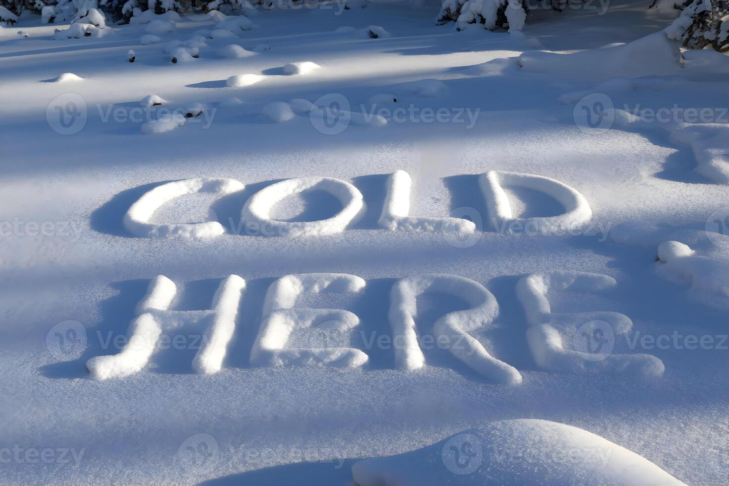 COLD HERE written in fresh snow with footprints scattered across the ground photo