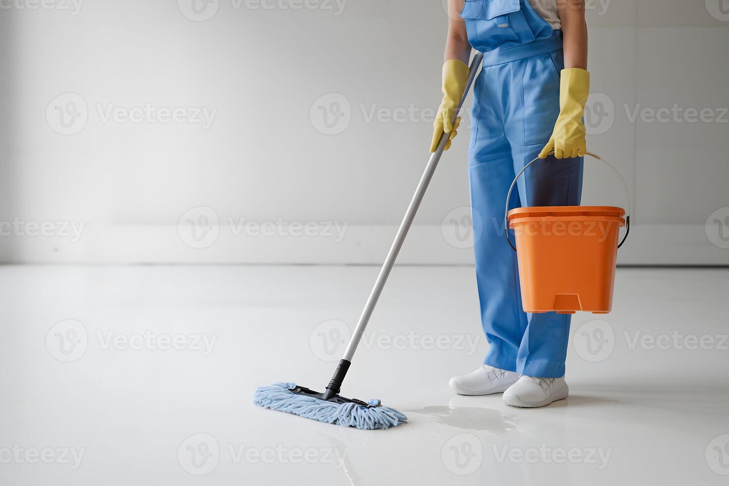 Person in blue work attire cleaning a space, minimalistic background emphasizes cleanliness photo