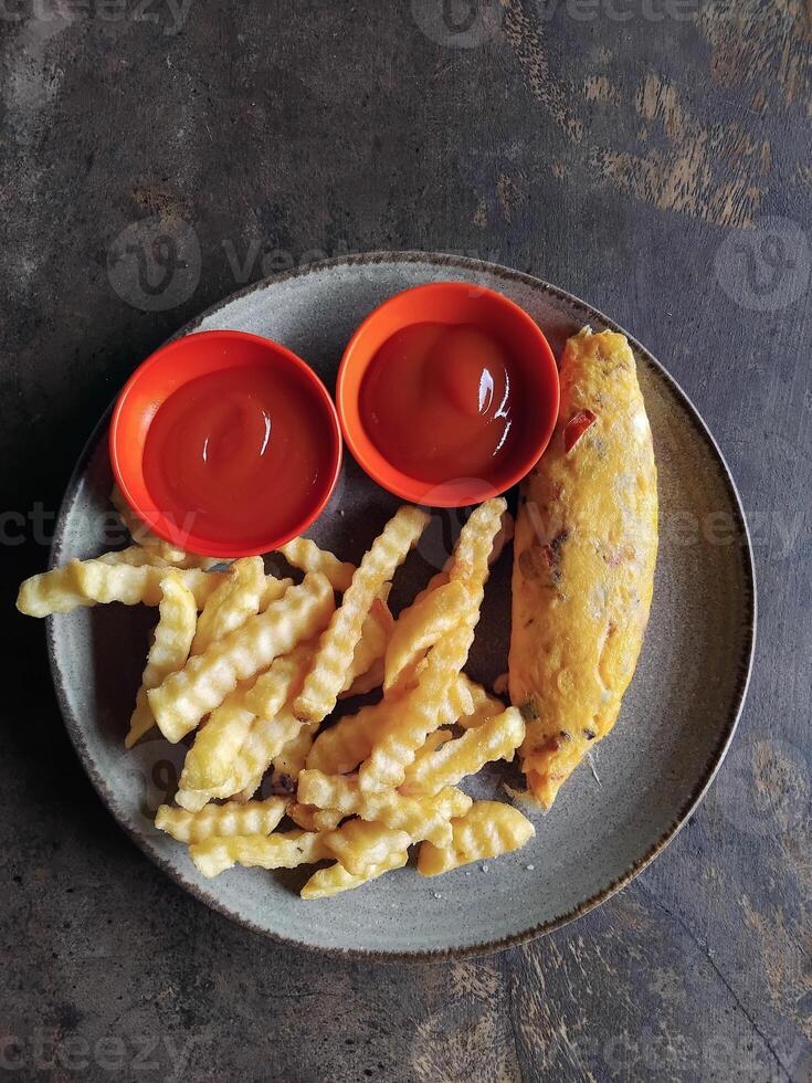 Fried fries and omelete with ketchup in tabel photo