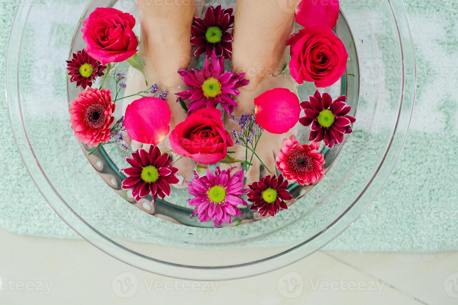 Foot bath in bowl with lime and tropical flowers, spa pedicure treatment, top view photo