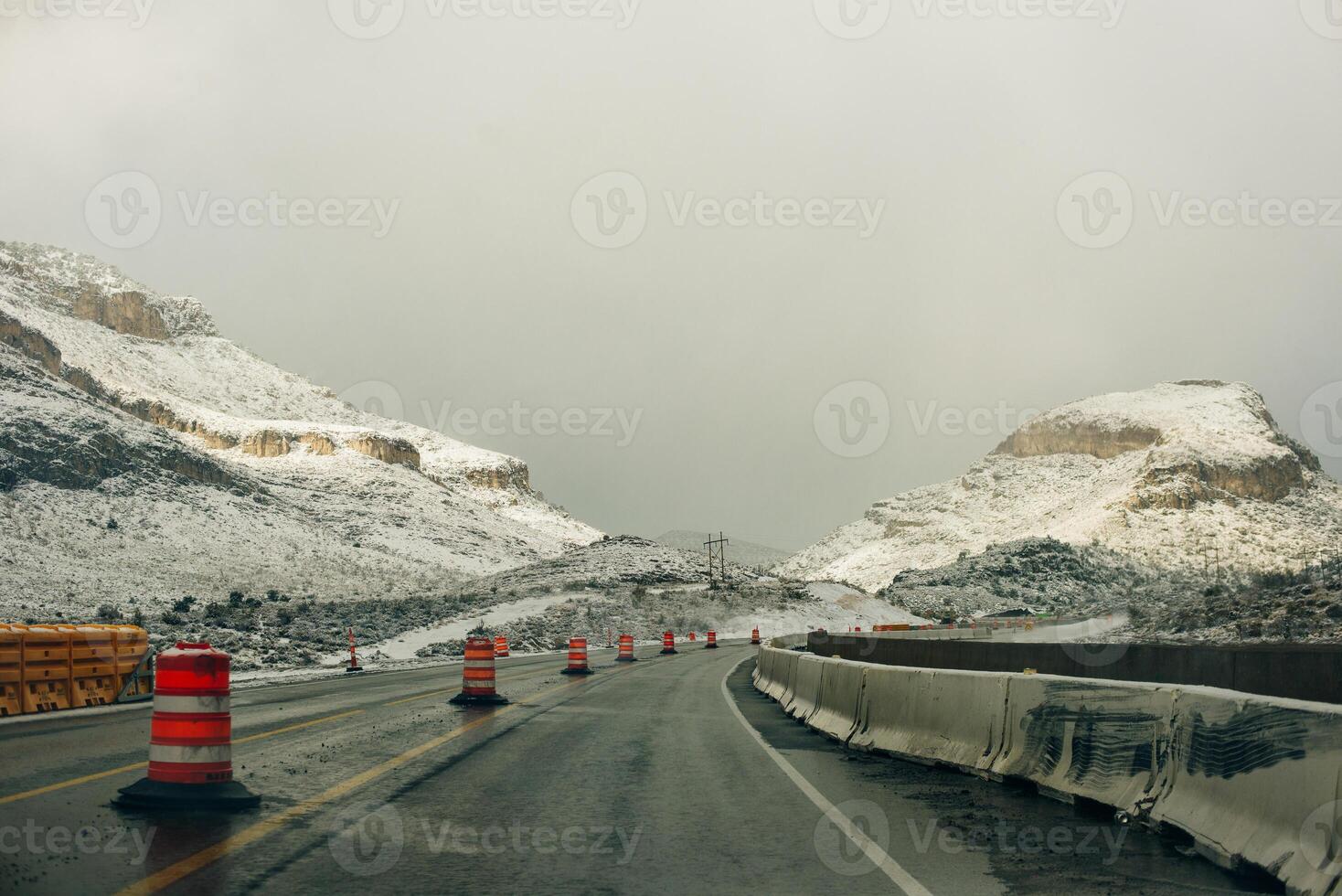 Bend along a snow covered road in a mountain setting in winter photo