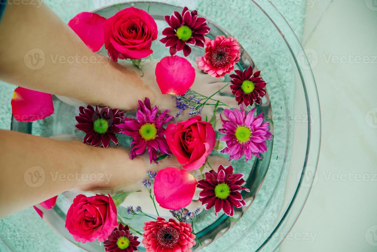 Foot bath in bowl with lime and tropical flowers, spa pedicure treatment, top view photo