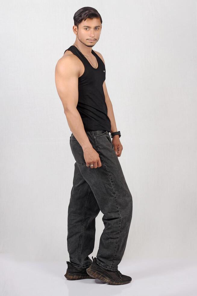 A man in a black tank top and gray pants photo