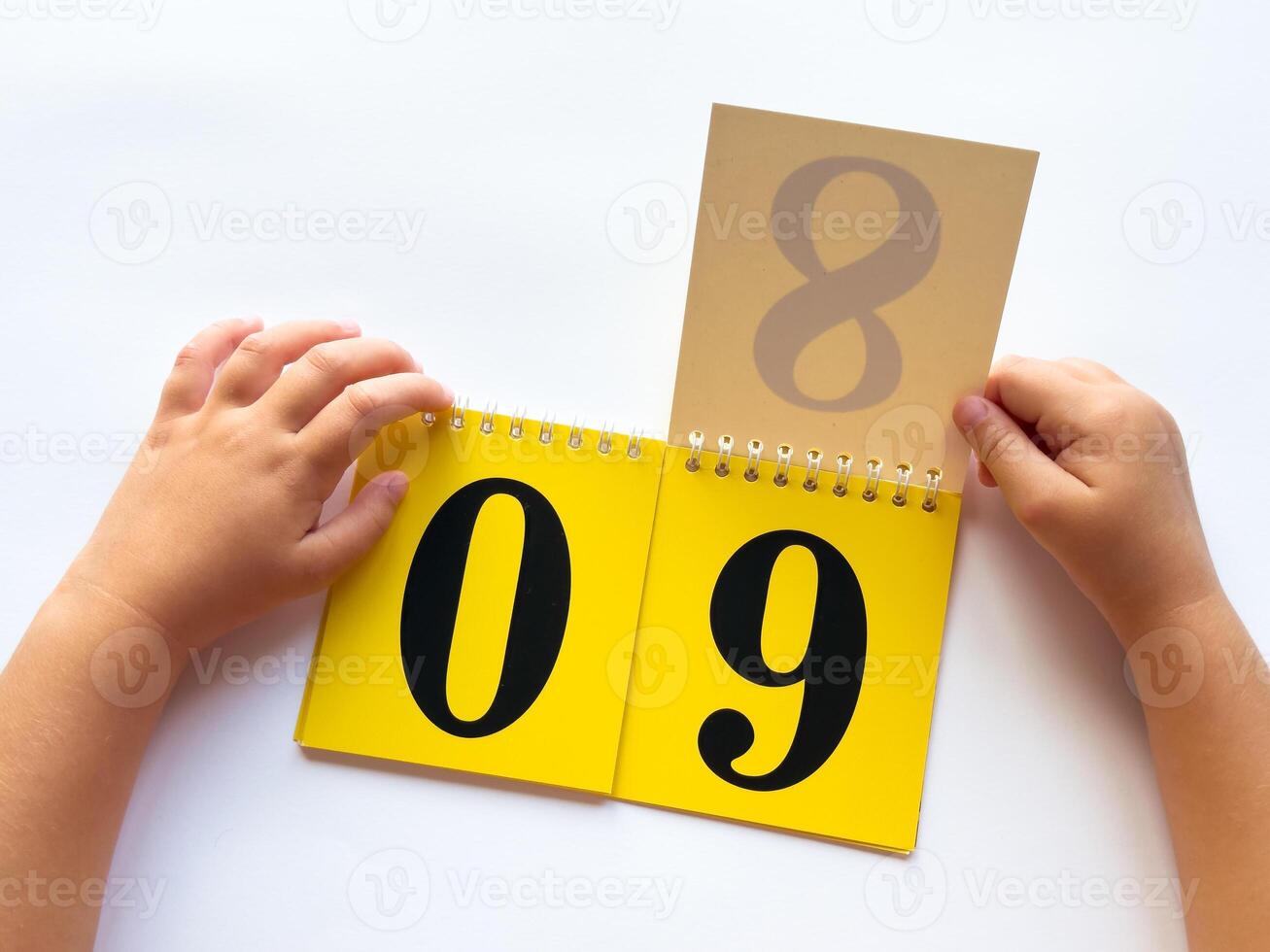 Childs hands flipping calendar to number nine on white background photo