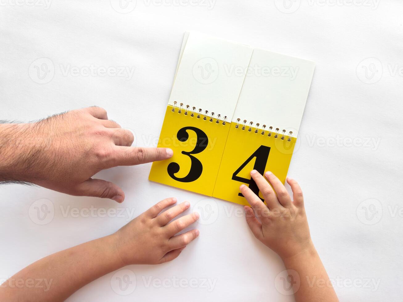 Parent and child learning numbers together with a yellow flip book photo