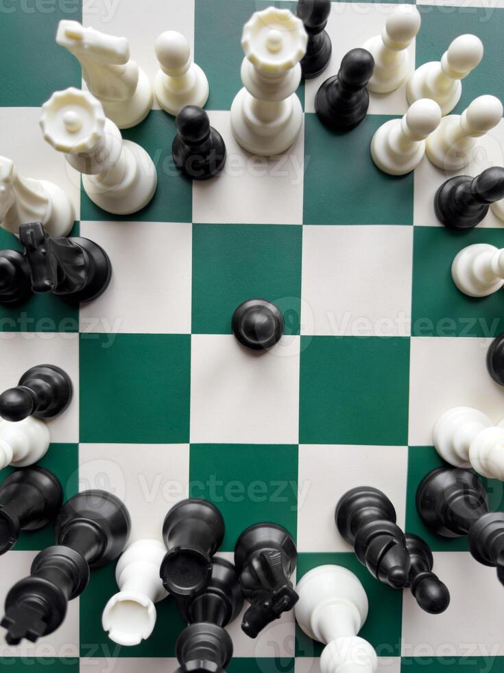 Dynamic chess game with vibrant black and white pieces on a checkered board photo