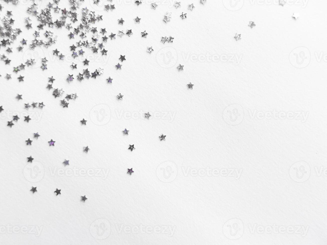 Silver star confetti on minimalist white background for festive designs photo