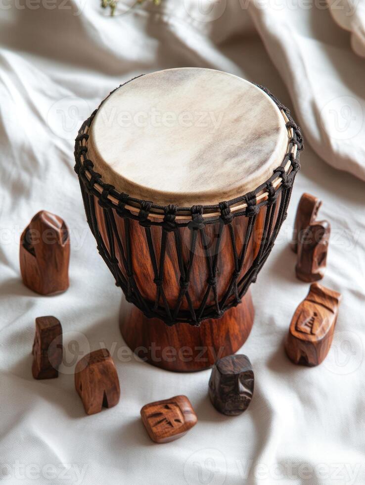 Top down view of a traditional African djembe drum surrounded by carved wooden figures photo