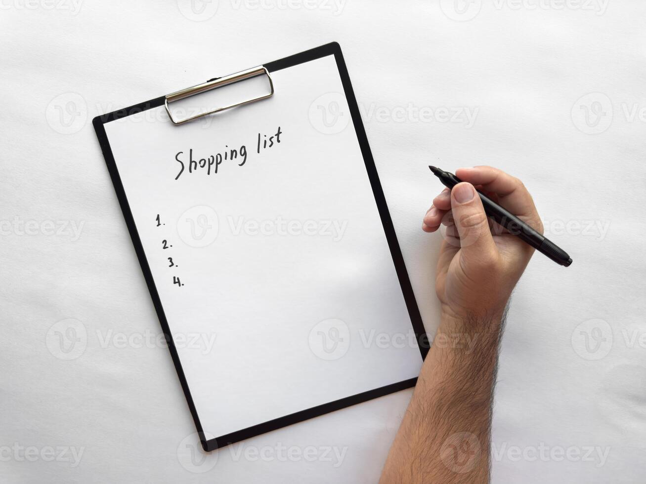 Handwriting a minimalist shopping list on clipboard photo