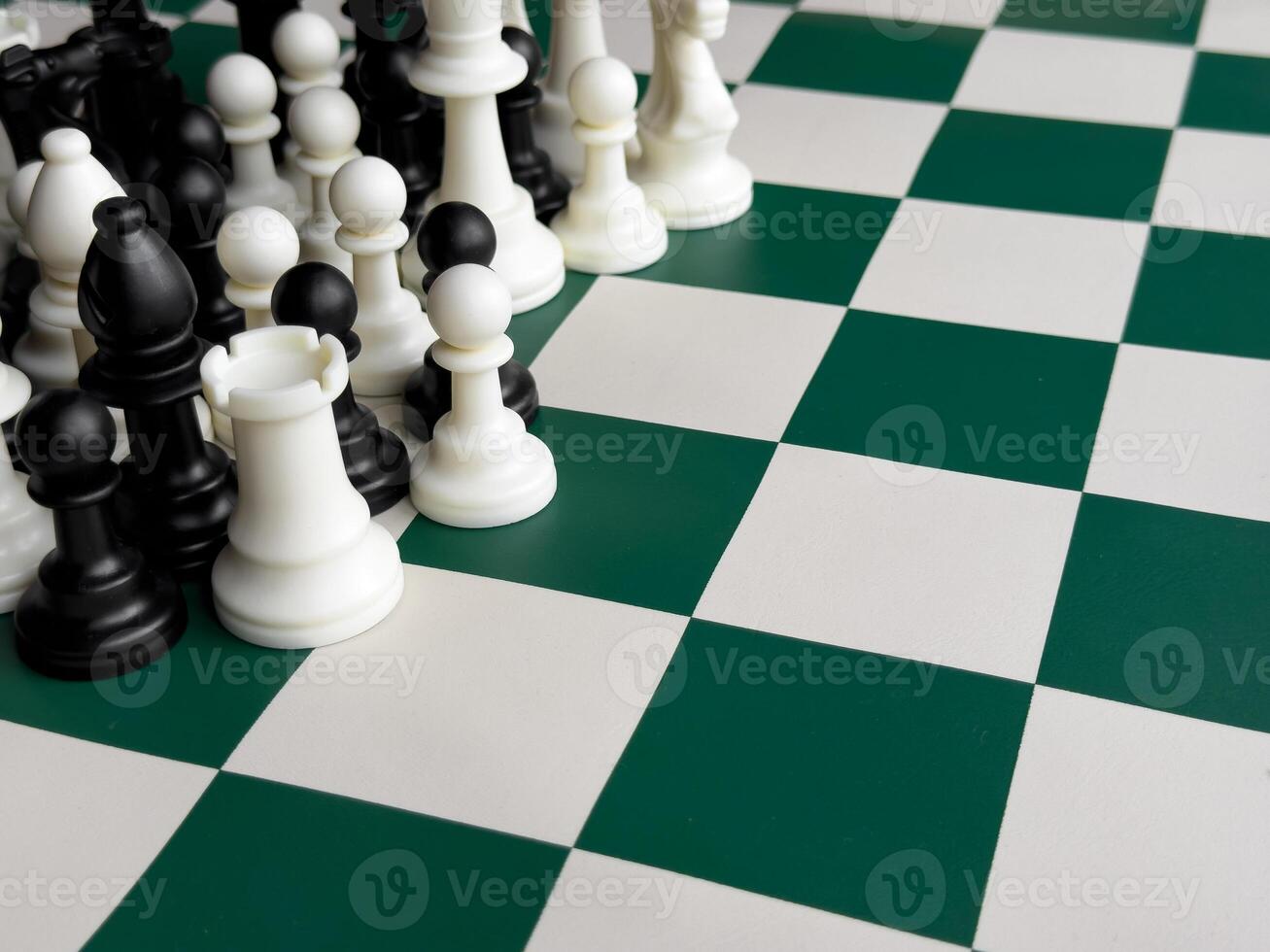 Chess game pieces on green and white board. Strategic game play and tactics photo