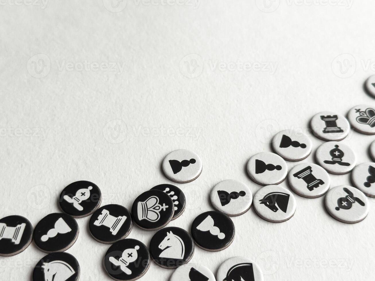 Chess themed tokens on white surface. Strategic game pieces in black and white photo