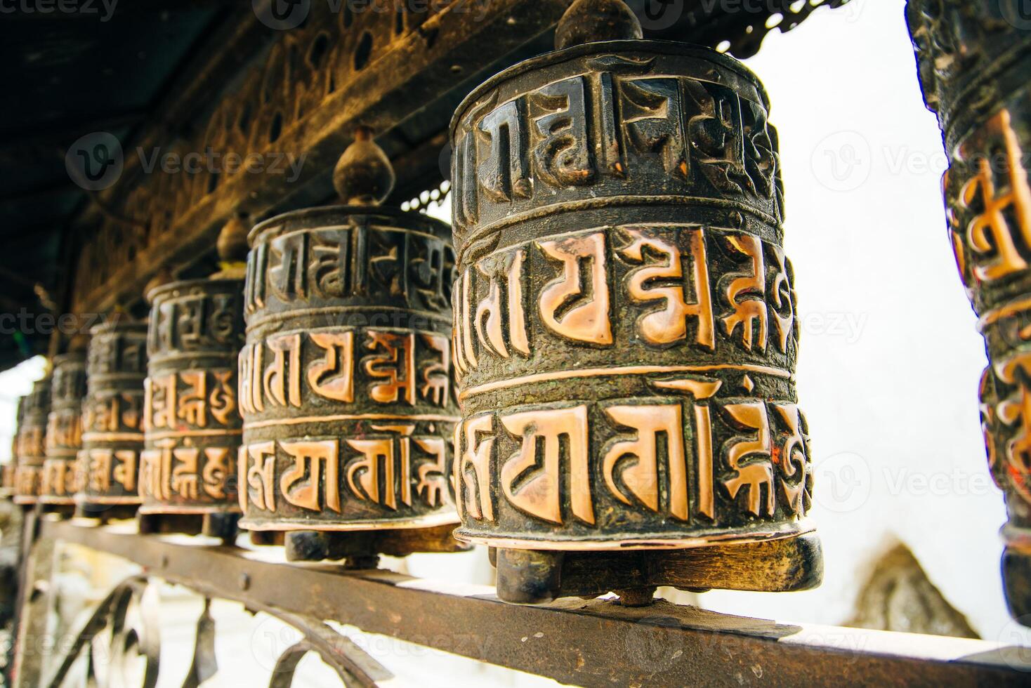 Prayer drum. Old prayer cylinders in Nepal. Tibetan Prayer wheels. Buddhist rolls in row photo