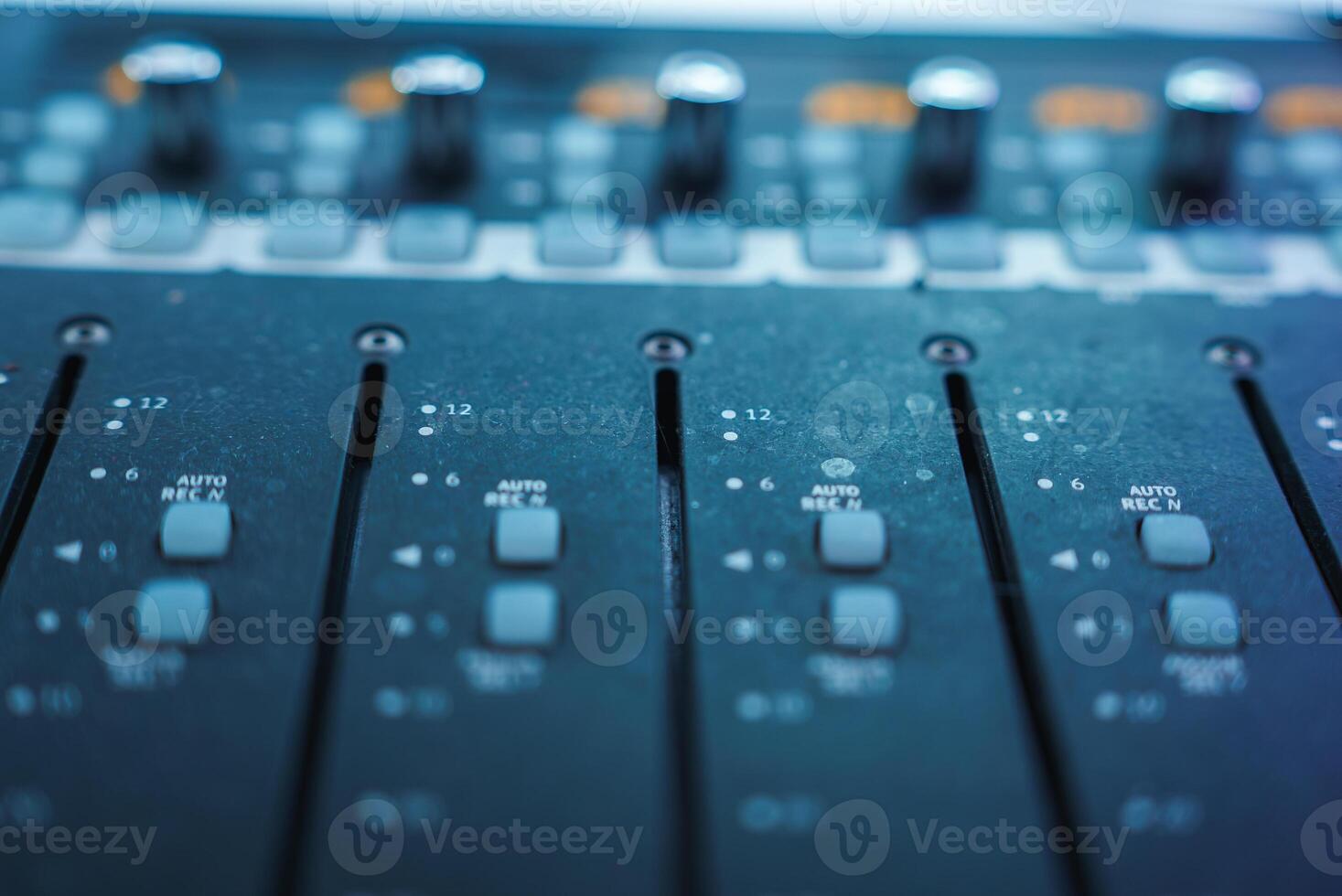 Close Up of Professional Audio Mixing Console with Faders and Knobs photo