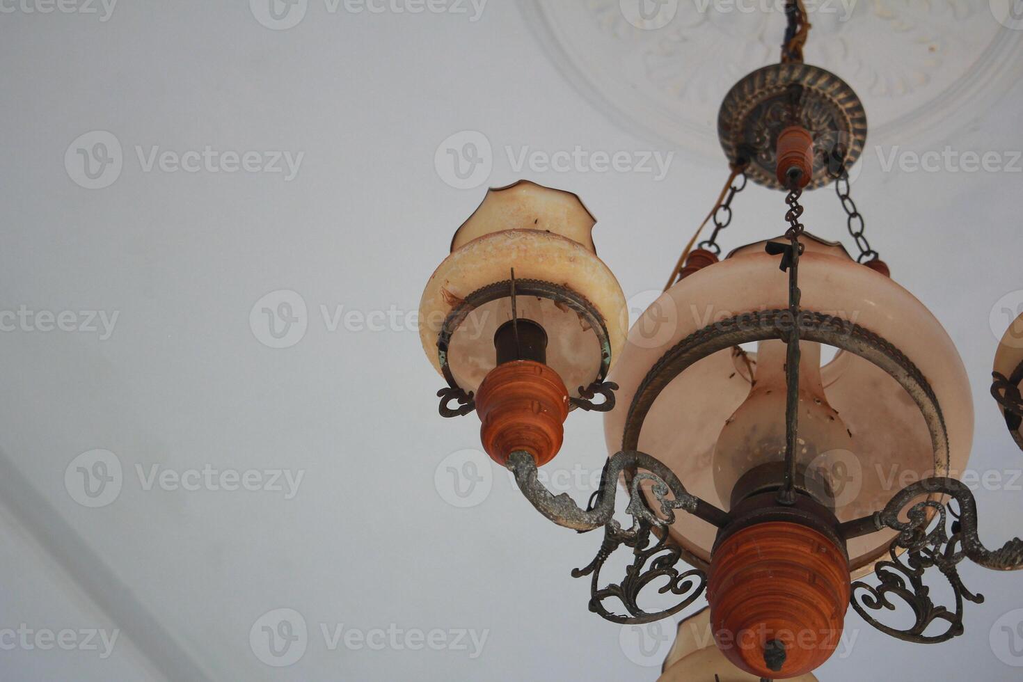 Elegant Vintage Chandelier with Ornate Design Hanging from a White Ceiling photo