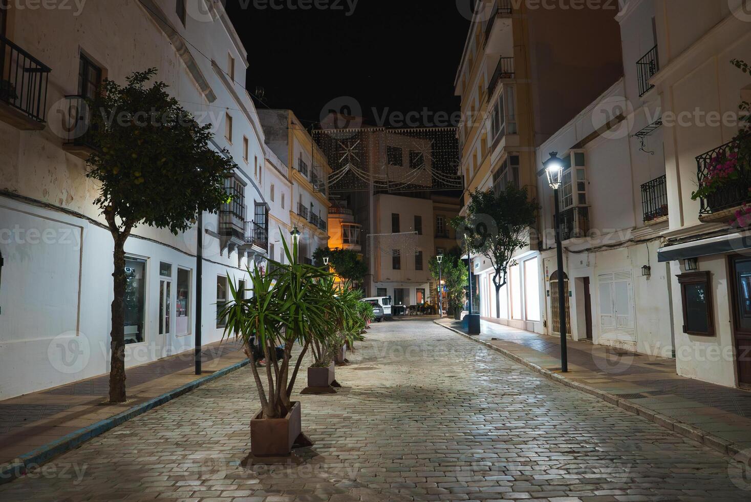 Nighttime View of a Narrow Street in Tarifa, Spain with Lights photo
