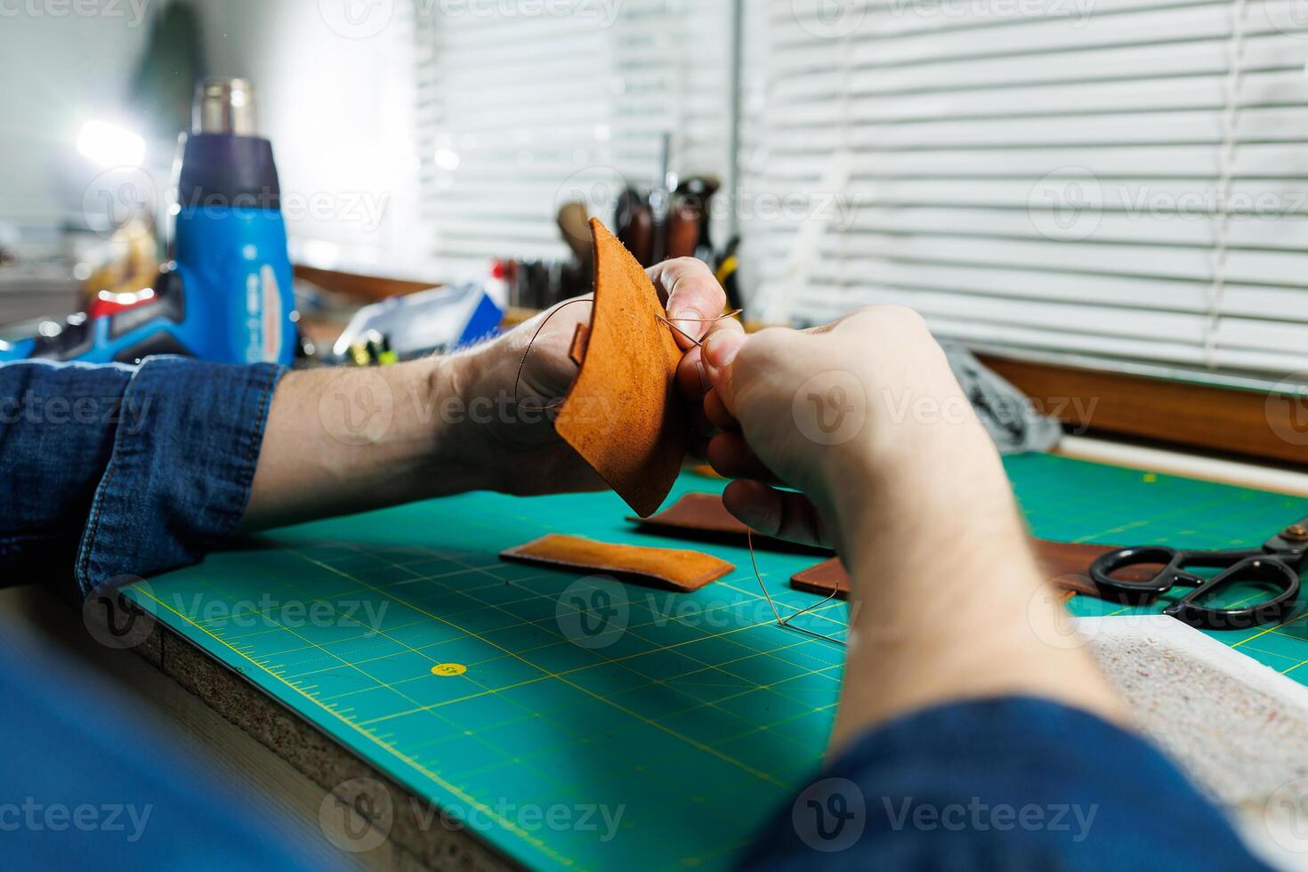 Close-up of male hands working with natural leather. Handmade products made of genuine leather. photo