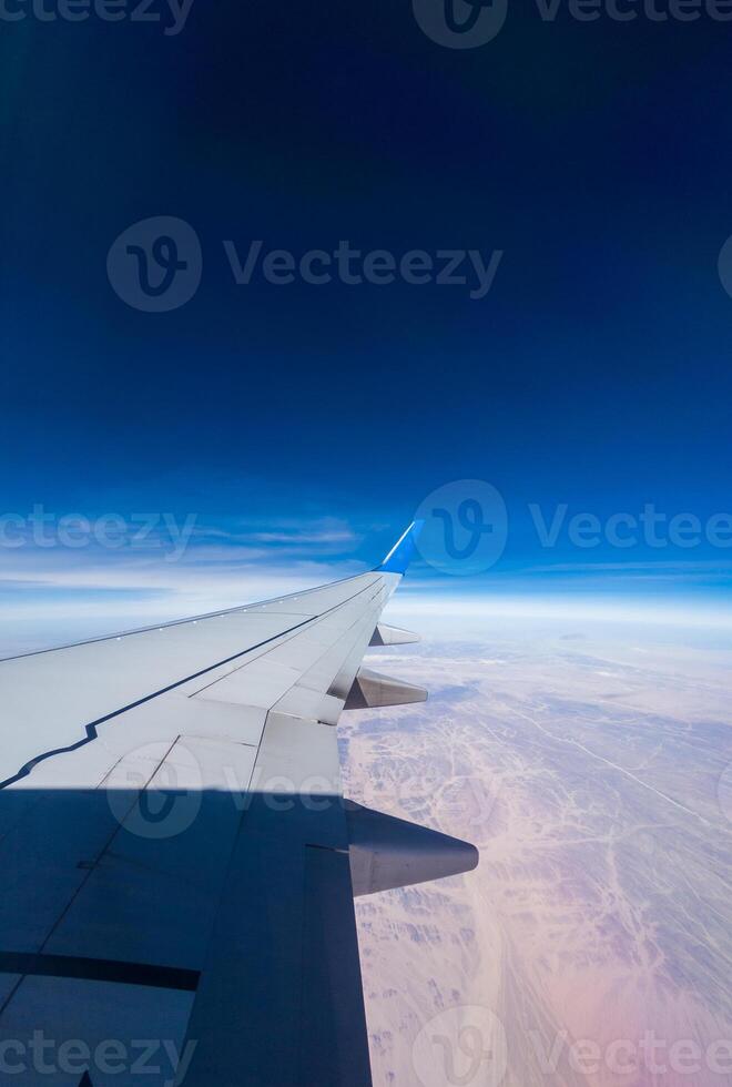 Plane wing with eluminator against the blue of the sky photo
