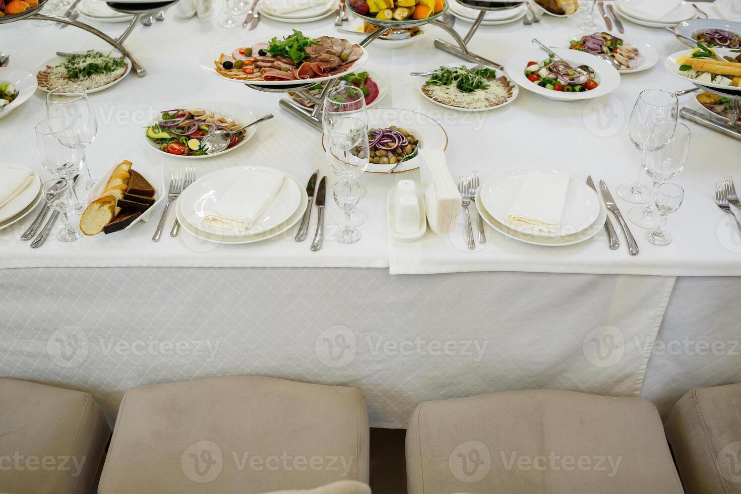 Serving a festive table in a restaurant. Preparation of a banquet for a holiday. Expensive decoration materials. Dishes for food and drinks photo