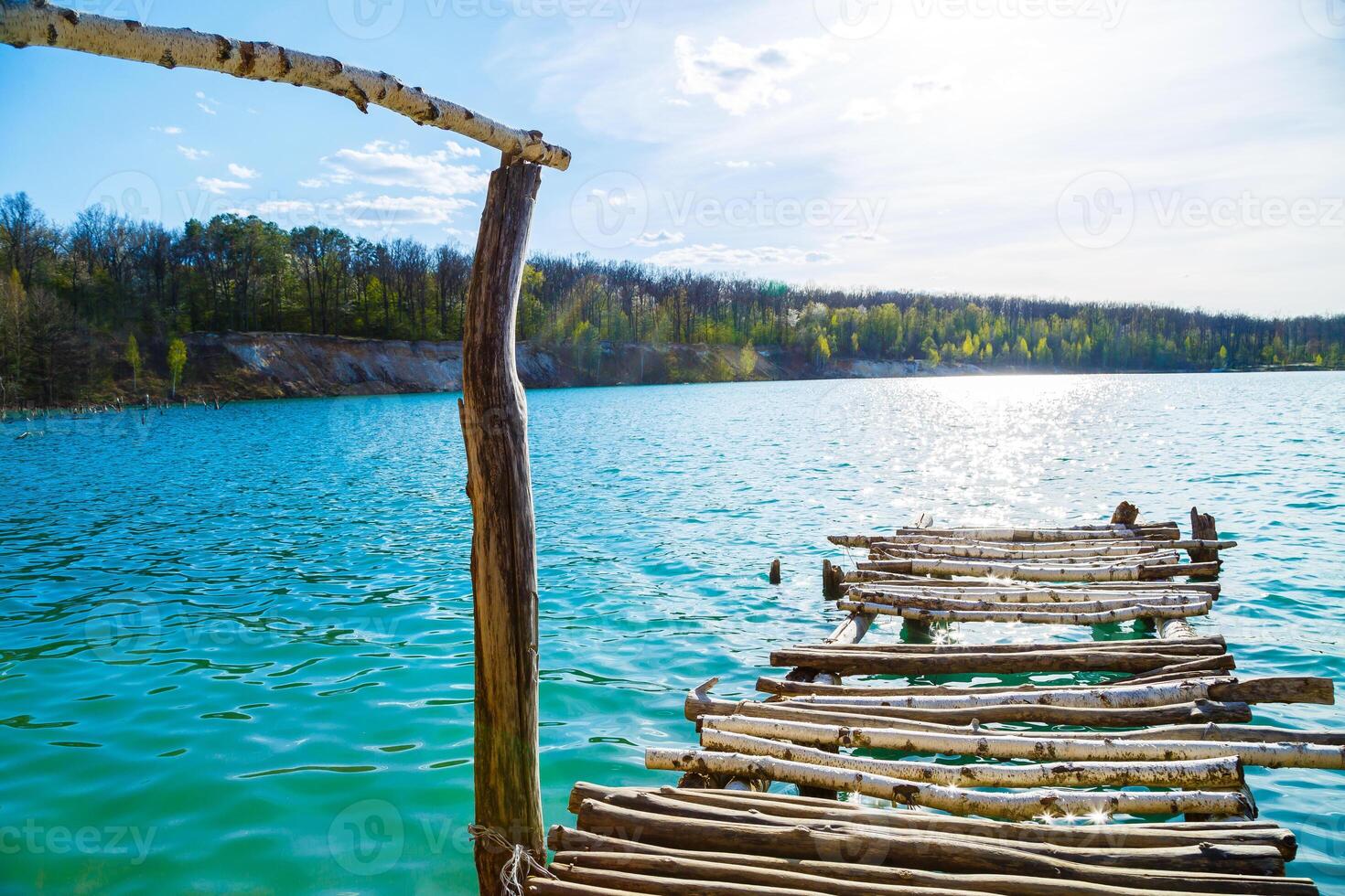 Wooden masonry stands on the water isolated. Entry into the lake from a wooden bridge into the lake photo
