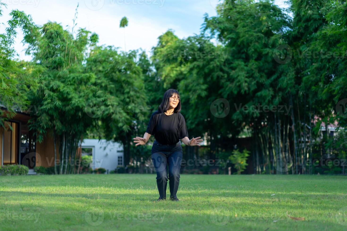 Asian short hair Woman is Joyful Jumping on the grass field garden. photo