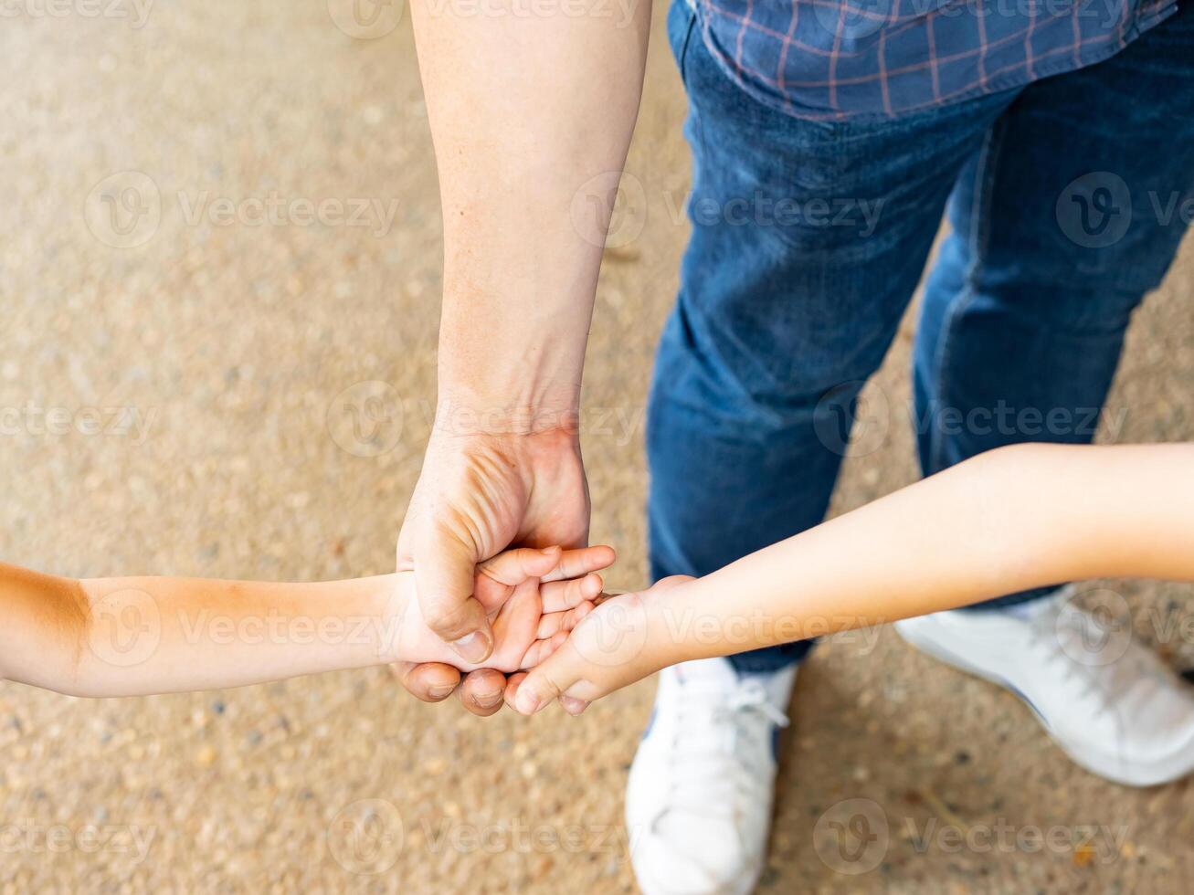 Close up of parent and baby join hands on the light background. Dad And two children joined hand together. Father holding hands of cute children. photo