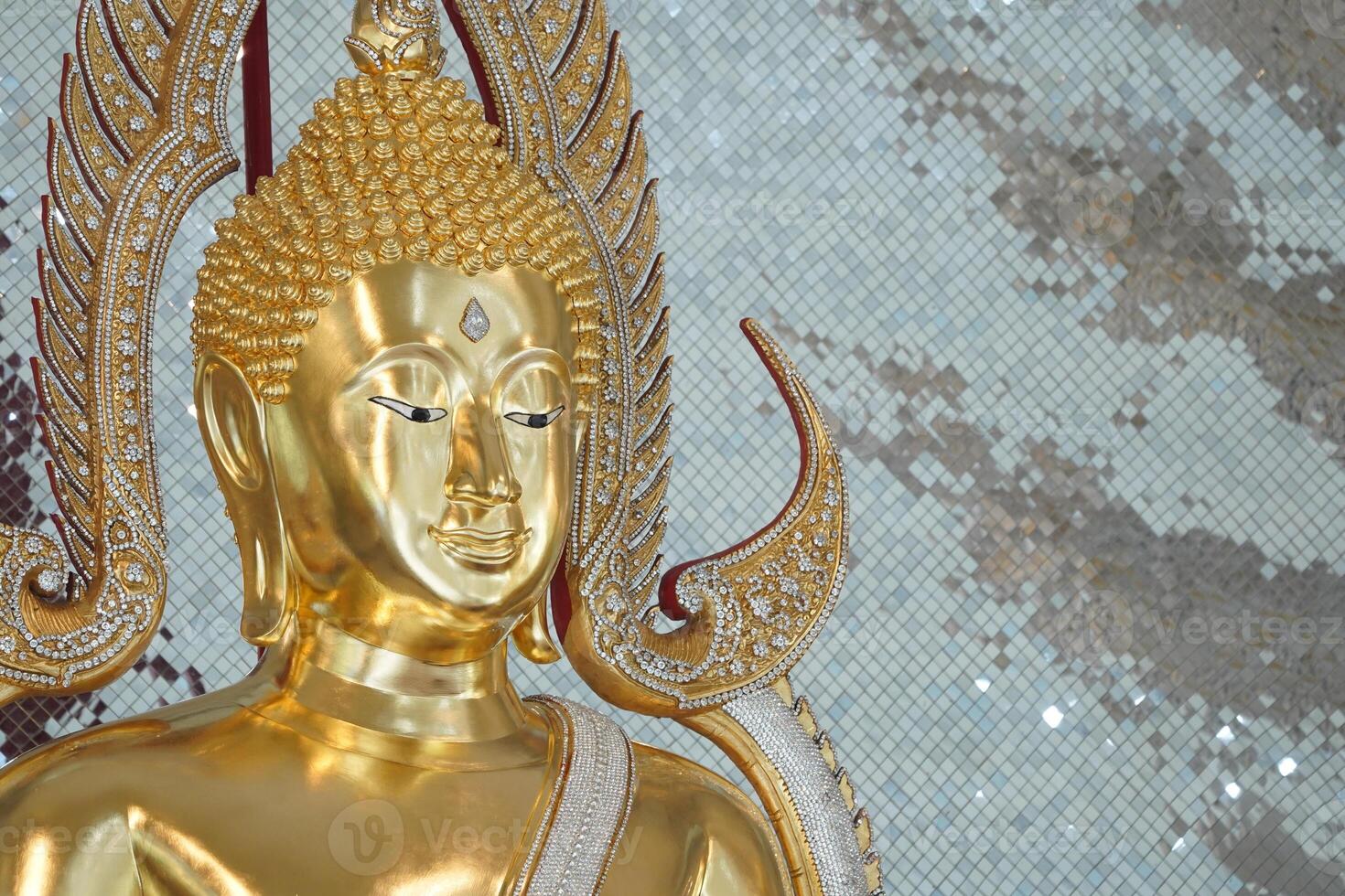 close up of golden Buddha statue is a stunning sight to behold. The intricate details and craftsmanship of the sculpture are clearly visible, showcasing the skill and talent of artist who created it. photo