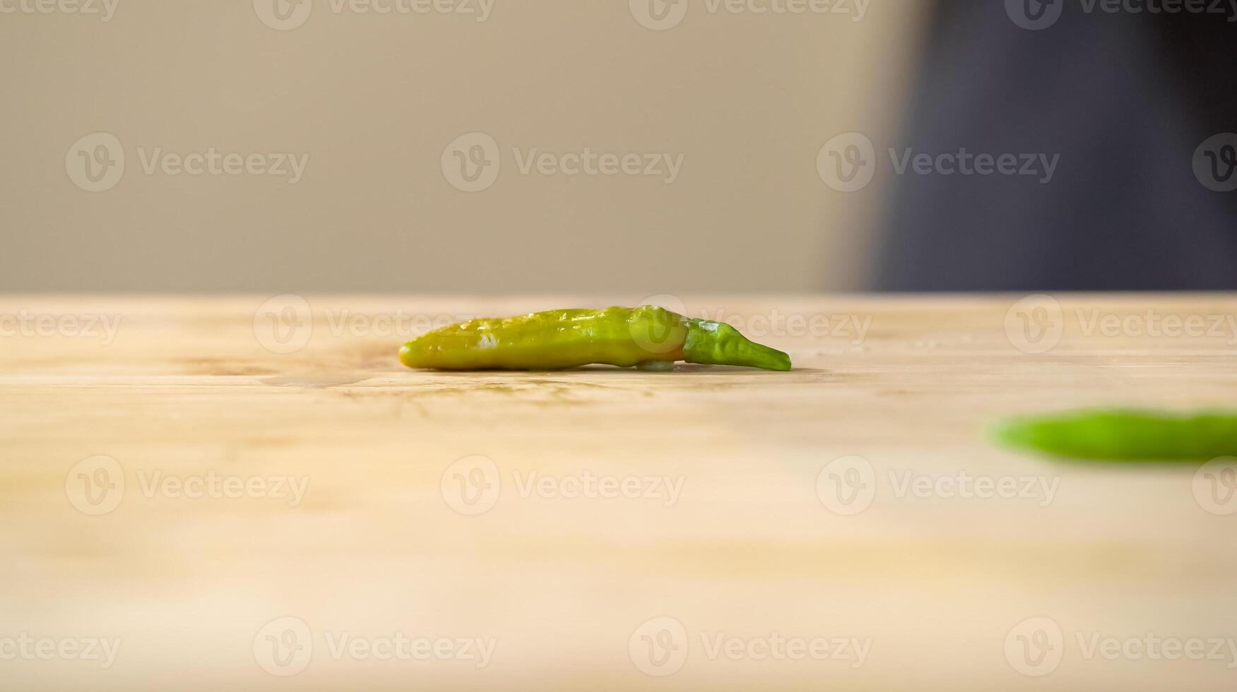Close up of chef butcher hitting bird chilli with knife on kitchen, cooking food.The chef butcher preparing chilli, ingredient for cooking. photo