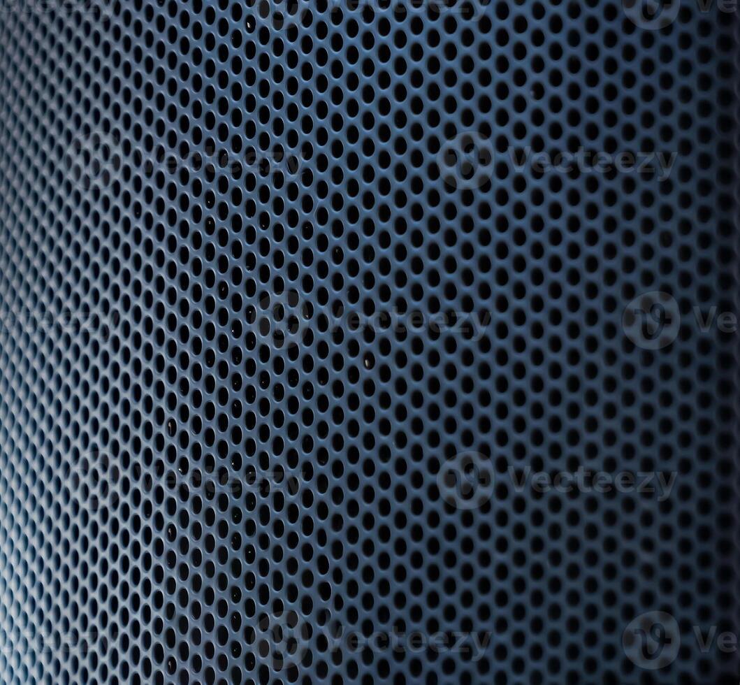 The close up photo of the modern black speaker and the metallic stand on a blurry background.
