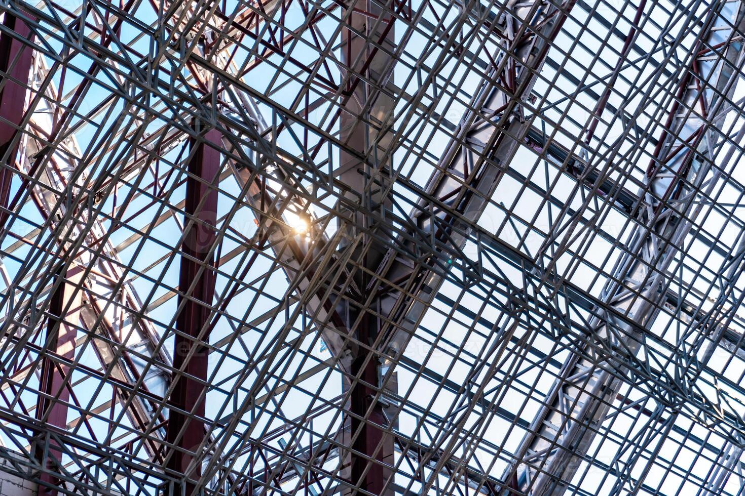 Uprisen angle photo shot of the huge steel roof frame structure detail under construction at the work site.