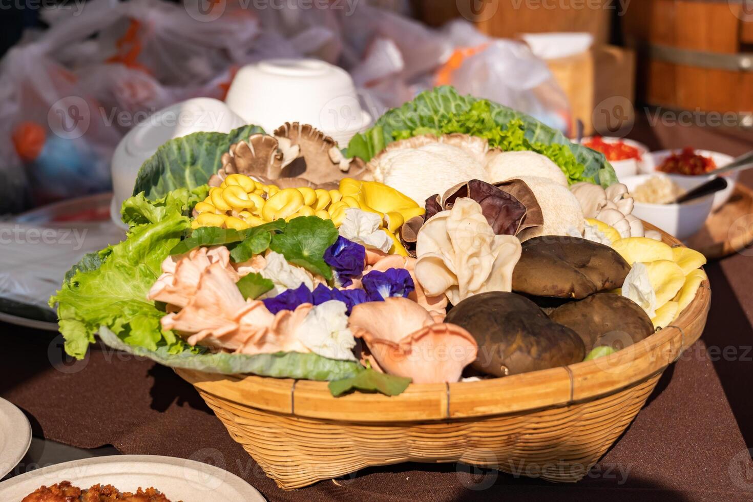 A delightful assortment of mushrooms adorns a rustic bamboo wicker, showcasing a Shiitake, Grey oyster, straw, Jelly, mushroom in the sunlight. photo
