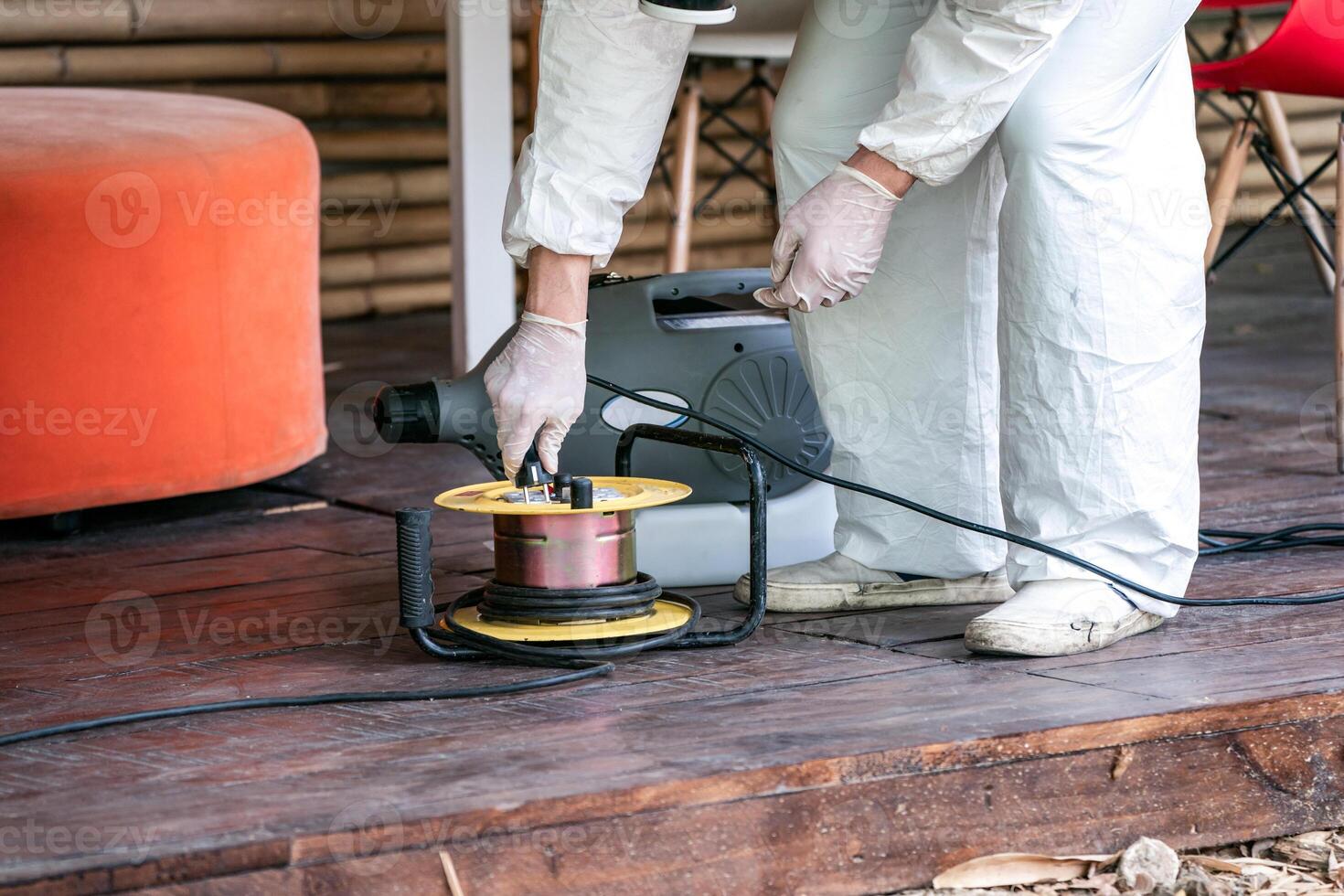 Professional technical man in prevention suit with his sterilizing machine and disinfecting water sprays in toilet or wc area field for purifying coronavirus COVID-19 photo